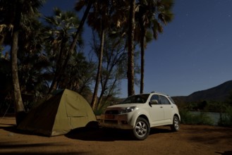 Tent and safari vehicle at night on a campsite near Epupa Falls, Epupa, Kaokoland, Kunene, Namibia,