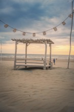 Fairy lights and wooden house on the beach at sunset, Zandvoort, Netherlands