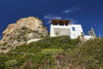 Green slope, rocky outcrop, white house, Levanzo village, Levanzo, Egadi Islands, Sicily, Italy,