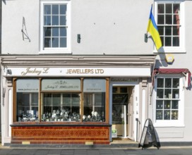 Support for Ukraine, Ukrainian national flag flying outside jeweller shop, Saxmundham, Suffolk,