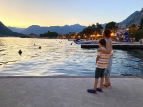 Evening atmosphere on the beach promenade of Kotor, mother with son, Bay of Kotor, Adriatic Sea,