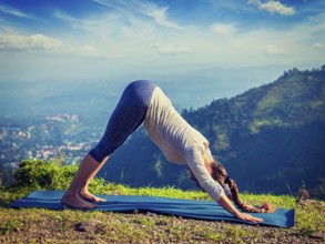 Yoga outdoors, young sporty fit woman doing Ashtanga Vinyasa Yoga asana Adho mukha svanasana,