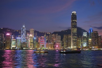 Hong Kong skyline cityscape downtown skyscrapers over Victoria Harbour in the evening illuminated