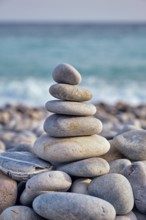 Zen meditation relaxation concept background, balanced stones stack close up on sea beach