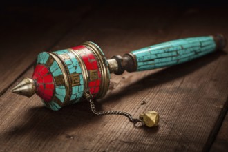 Tibetan buddhist Mani wheel or hand prayer wheel on wooden background