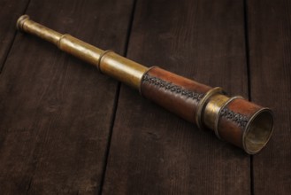 Vintage retro spyglass on wooden background