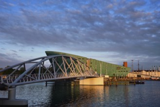 AMSTERDAM, NETHERLANDS, MAY 9, 2017: NEMO Science museum and Mr. J. van der Veldebrug bridge. It is