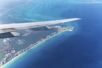 Aerial view through plane window of Caribbean coastline buildings in the hotel zone, Cancun,