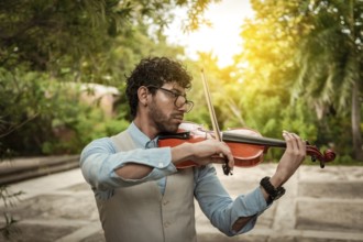 Portrait of man playing violin at sunset. Close up of violinist man playing in the street.