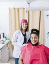 Portrait of dentist with patient smiling at camera in office, Female dentist with satisfied patient