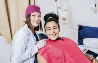 Female dentist with smiling female patient looking at camera, Professional dentist with female