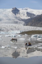 Boats with tourists in the glacier lagoon, ice lagoon Fjallsárlón, ice floes in front of glacier