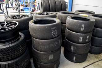 Used tyre pile of used worn tyres Racing tyres middle right Slicks left Rain tyres in front of pit