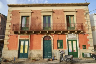 Old house, old rose-coloured façade, green windows and doors, balcony, scooter, Malfa, Salina,