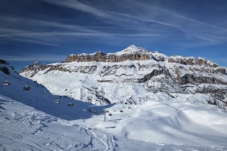 View of a ski resort piste with people skiing in Dolomites in Italy. Ski area Arabba. Arabba,