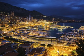 Aerial view of Monaco Monte Carlo harbour and illuminated city skyline in the evening blue hour