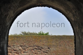 The pentagonal Fort Napoleon in the dunes near Ostend, Belgium. Viev over brick wall through window