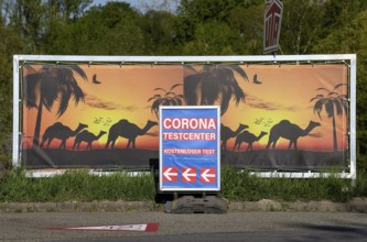 Sign Corona Testcenter in front of camels, border crossing between Gambsheim (France) and