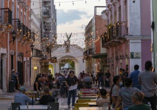 Restaurant tables in street at night with hanging lights, Campeche city, Campeche State, Mexico,