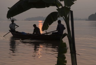 Fishermen boat passing next to a banana tree instralled for upcoming Chhath Puja festival, in the