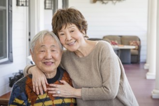 Happy senior chinese couple pose for their portrait on the porch