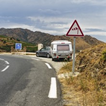 Border crossing, mountain pass Coll dels Belitres, traffic sign warns of wind, crosswind from the