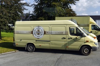 Old van with logo and slogan on car park, visitor centre of the Warsteiner brewery, Warstein,