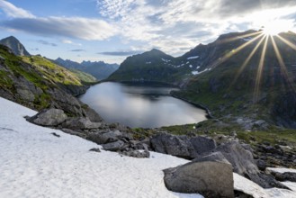 Mountain landscape with lake Tennesvatnet, at sunrise with sun star, Moskenesøya, Lofoten,