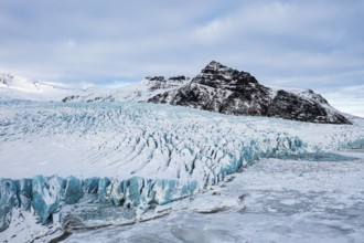 Snow-covered icebergs in the Fjallsarlon glacier lagoon, with the Öraefajökull glacier behind,