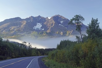 Traffic-free road, fog, foliage and snow-covered mountains, Richardson Highway, Alaska, USA, North