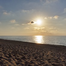 Sunbeams in a slightly cloudy sky, sunset by the sea, deserted sandy beach in autumn, Spiaggia di