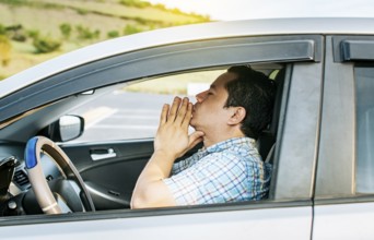 Close up of driver praying in his vehicle, Driver male praying in his vehicle before leaving.