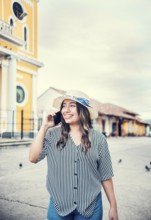 Happy travel woman calling on the phone in a tourist plaza. Beautiful tourist girl talking on cell