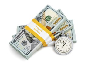 Time is money loan concept background, stopwatch and stack of new 100 US dollars 2013 edition