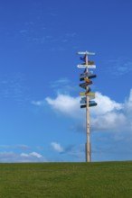 Signpost on dyke to local and world places, Nordstrand peninsula, North Frisia, Schleswig-Holstein,