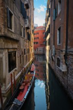 Narrow canal between colorful old houses with gondola boat in Venice, Italy, Europe