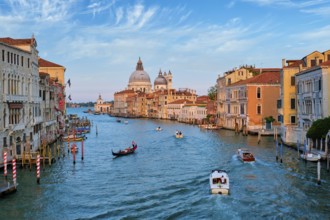 View of Venice Grand Canal with boats and Santa Maria della Salute church on sunset from Ponte