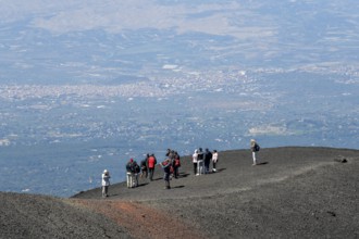 Hikers in the crater landscape of the volcano Etna, summit region, province of Catania, Sicily,