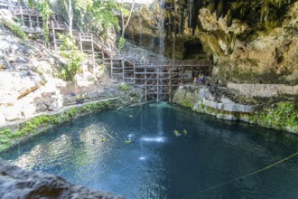 People swimming in Cenote Zaci carboniferous limestone swallow hole pool, Valladolid, Yucatan,