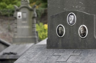 Old pictures on family grave, tomb at cemetery in autumn