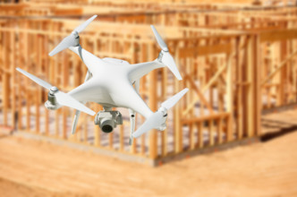 Unmanned aircraft system (UAV) quadcopter drone in the air over construction site