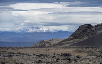 Volcanic landscape, barren landscape, snow-covered cloudy mountains in the back, Vatnajökull