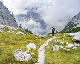 Mountaineer on a hiking trail, cloudy mountains, descent over the Ofental, mountain tour on the