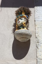 Flowerpot with a face on a house wall and planted with a cactus, Sicily, Italy, Europe