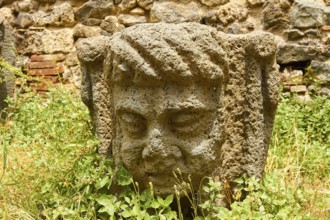 Head of a stone figure, grass, wall, Randazzo, town, Nebrodi National Park, Sicily, Italy, Europe