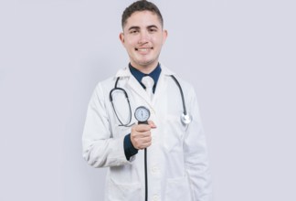 Cheerful doctor holding blood pressure monitor. Young doctor showing blood pressure monitor