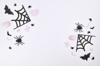 Pink and black Halloween decoration on sides of white background with copy space