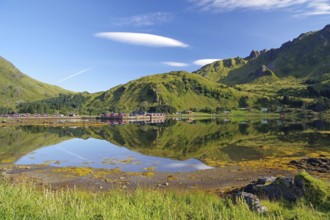 Wooden houses reflected in shallow fjord water, holiday cabins, Brustranda Sjøcamping, Valberg,