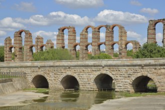 Roman stone arch bridge Puente Romano de la Puerta over the Rio Albarregas and aqueduct Acueducto