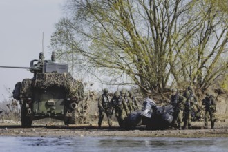 Czech and German soldiers launch an inflatable boat into the Elbe as part of the military exercise